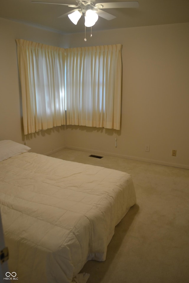 carpeted bedroom with ceiling fan and baseboards