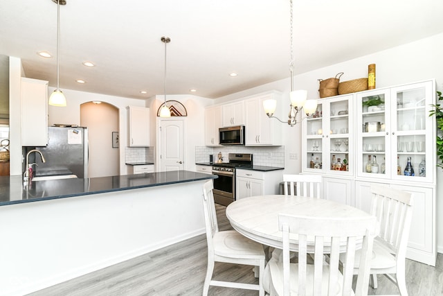 89 Kinnick Dr, Greenwood, IN 46143 - kitchen featuring stainless steel appliances, dark countertops, white cabinetry, arched walkways, and recessed lighting
