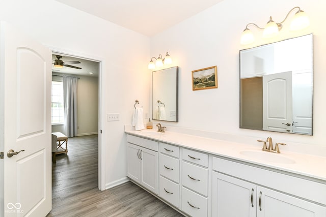 89 Kinnick Dr, Greenwood, IN 46143 - bathroom with baseboards, wood finished floors, double vanity, and a ceiling fan