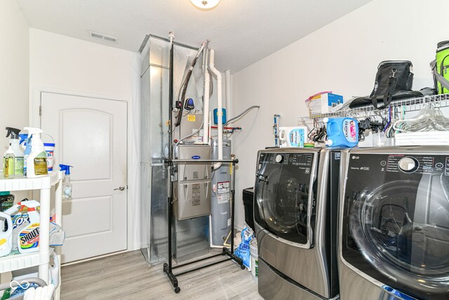 89 Kinnick Dr, Greenwood, IN 46143 - washroom featuring separate washer and dryer, light wood-type flooring, and water heater