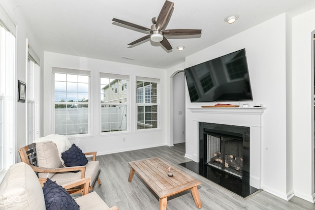 89 Kinnick Dr, Greenwood, IN 46143 - living room with a ceiling fan, wood finished floors, a fireplace with raised hearth, and baseboards