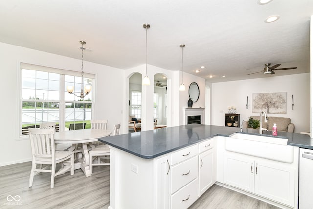 89 Kinnick Dr, Greenwood, IN 46143 - kitchen featuring a sink, dark countertops, open floor plan, arched walkways, and ceiling fan