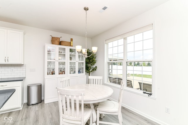 89 Kinnick Dr, Greenwood, IN 46143 - dining area with light wood finished floors, a chandelier, and baseboards