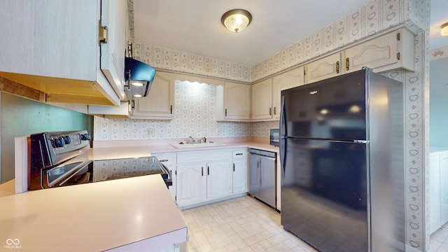 kitchen with wallpapered walls, stainless steel appliances, a sink, light countertops, and ventilation hood