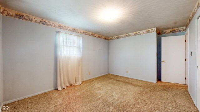 unfurnished room with light colored carpet and baseboards