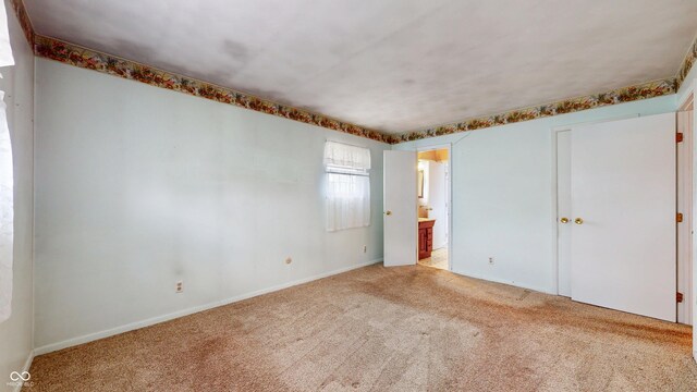 empty room with carpet and baseboards