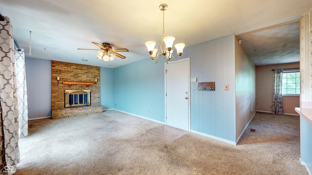 unfurnished living room with carpet flooring, a brick fireplace, ceiling fan, and baseboards