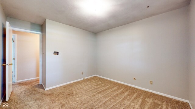 unfurnished room with light carpet and baseboards