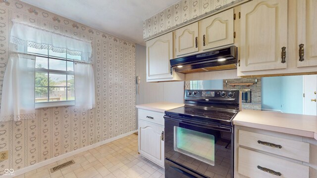 kitchen featuring black range with electric stovetop, under cabinet range hood, wallpapered walls, light countertops, and baseboards