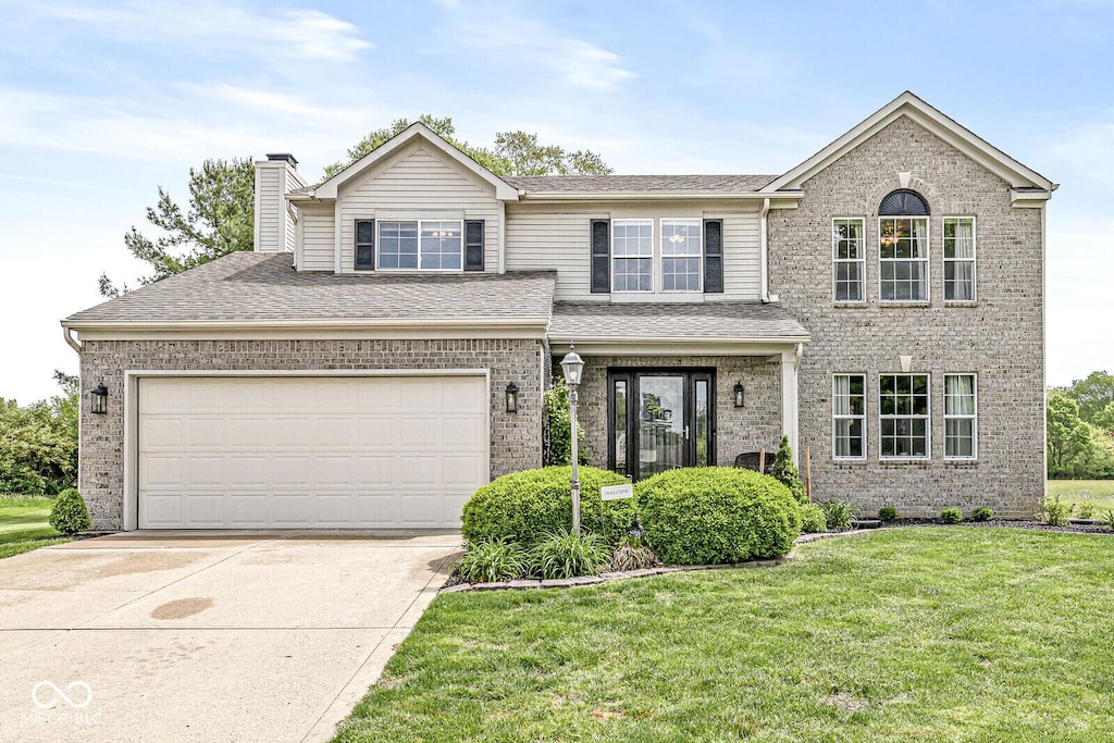 523 Torrey Ct, Avon, IN 46123 - view of front of property with brick siding, a front lawn, concrete driveway, a chimney, and an attached garage