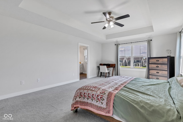 6305 Norwich Dr, Brownsburg, IN 46112 - carpeted bedroom featuring a raised ceiling, baseboards, ceiling fan, and ensuite bath
