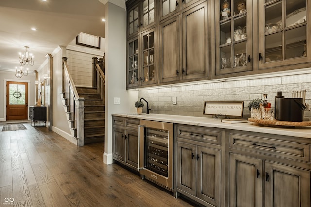 6734 W Stonegate Dr, Zionsville, IN 46077 - bar with beverage cooler, ornamental molding, baseboards, a chandelier, and tasteful backsplash