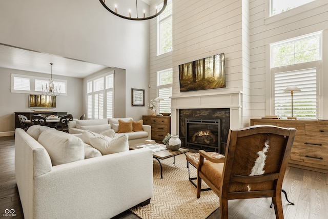 6734 W Stonegate Dr, Zionsville, IN 46077 - living room featuring a chandelier, wood finished floors, a towering ceiling, and a high end fireplace