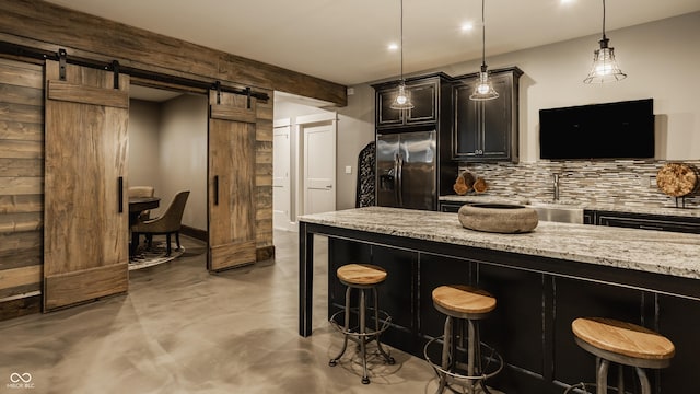 6734 W Stonegate Dr, Zionsville, IN 46077 - kitchen with stainless steel refrigerator with ice dispenser, concrete floors, tasteful backsplash, a barn door, and a kitchen breakfast bar