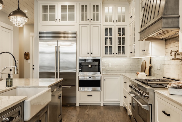 6734 W Stonegate Dr, Zionsville, IN 46077 - kitchen with high end appliances, custom range hood, a sink, pendant lighting, and white cabinets