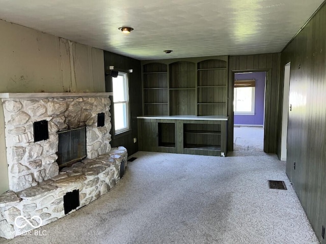 3209 Mounds Rd, Anderson, IN 46016 - unfurnished living room featuring a fireplace, carpet floors, and wood walls