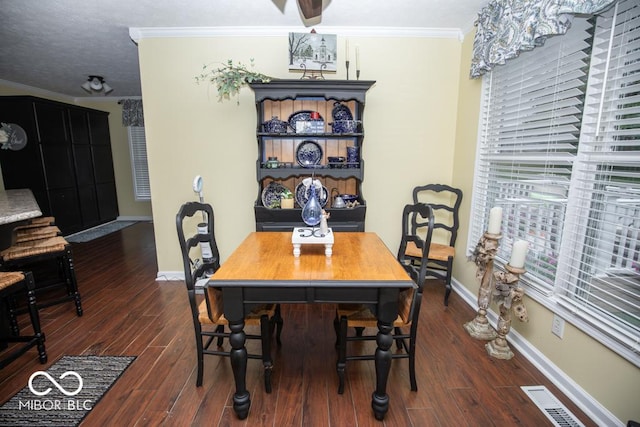 dining space with ornamental molding, baseboards, and dark wood-type flooring