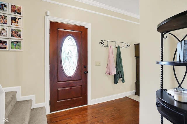 foyer entrance with baseboards, dark wood finished floors, crown molding, and stairs