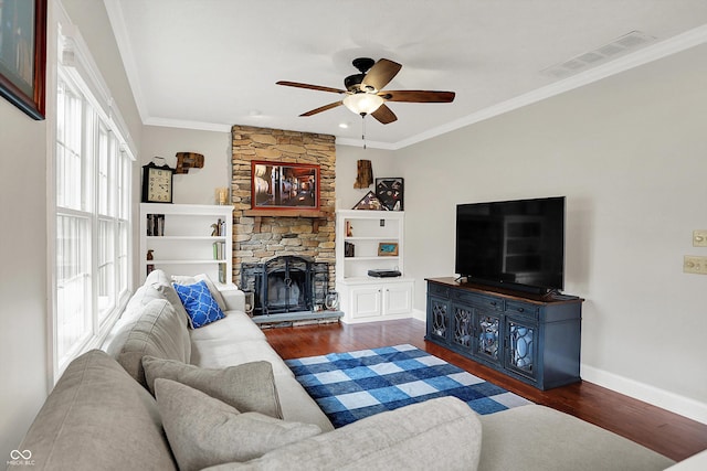 living room with wood finished floors, a ceiling fan, crown molding, baseboards, and a fireplace