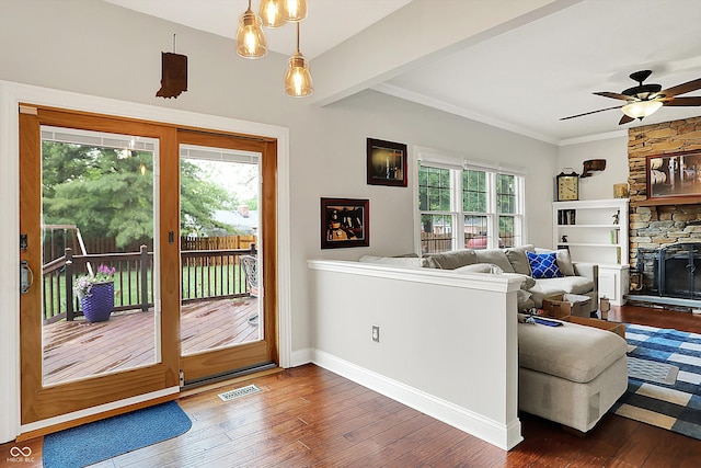 living room with hardwood / wood-style flooring, a ceiling fan, a fireplace, crown molding, and baseboards