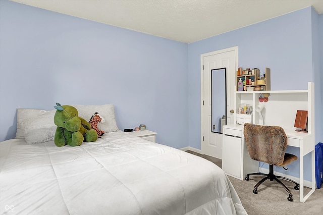 bedroom with carpet flooring, baseboards, and an office area
