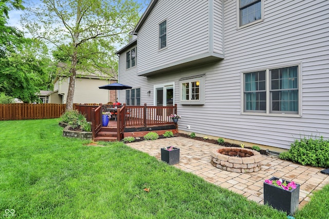 back of house with an outdoor fire pit, a patio, and a deck