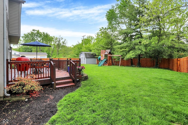 view of yard with a shed, a playground, an outbuilding, and a deck