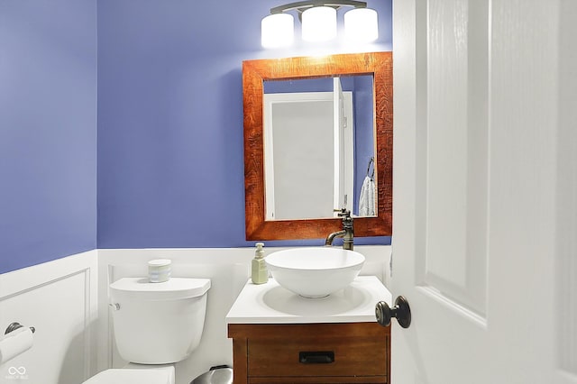 half bathroom with vanity and toilet