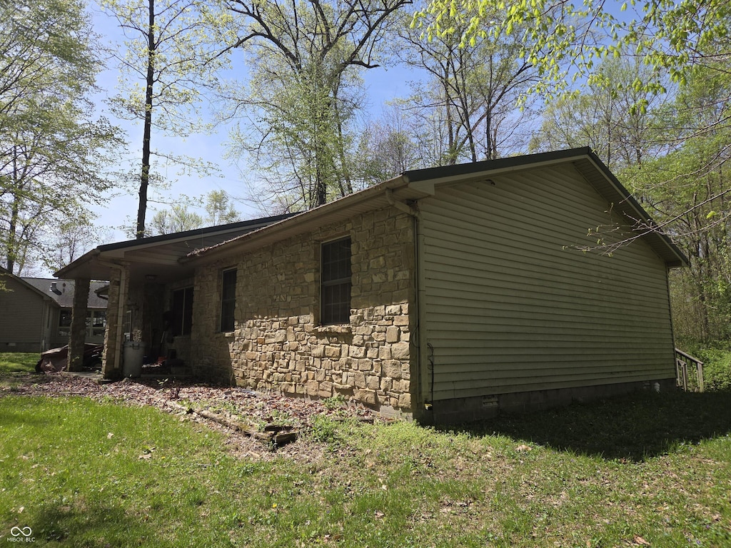 view of property exterior with stone siding, crawl space, and a lawn