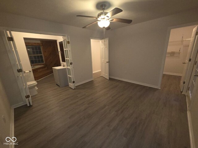 885 S Norkay St, North Vernon, IN 47265 - unfurnished bedroom with dark wood-style flooring, a spacious closet, and a ceiling fan
