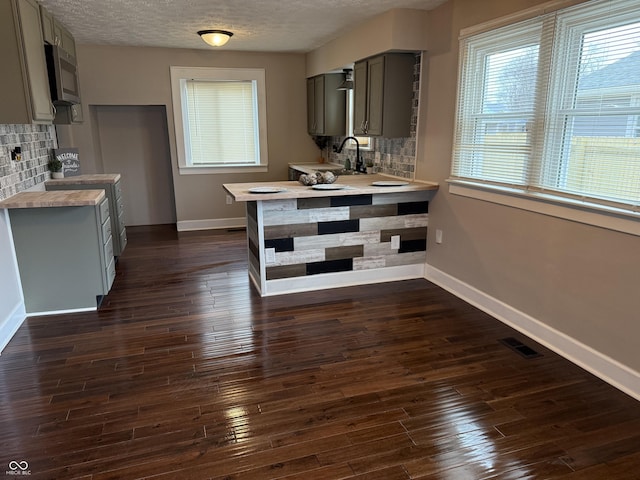 3720 W 16th St, Indianapolis, IN 46222 - kitchen featuring gray cabinets, stainless steel microwave, baseboards, tasteful backsplash, and a textured ceiling