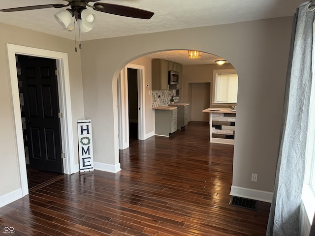 3720 W 16th St, Indianapolis, IN 46222 - spare room featuring arched walkways, ceiling fan, baseboards, and dark wood-style floors