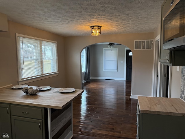3720 W 16th St, Indianapolis, IN 46222 - kitchen with butcher block counters, arched walkways, a textured ceiling, dark wood finished floors, and baseboards