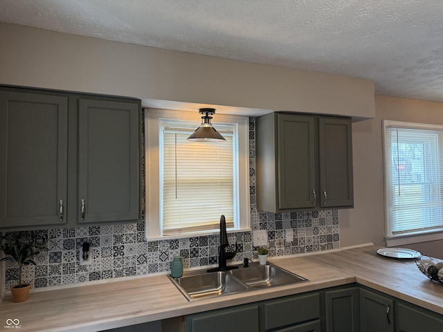 3720 W 16th St, Indianapolis, IN 46222 - kitchen with butcher block countertops, a sink, a textured ceiling, gray cabinetry, and decorative backsplash