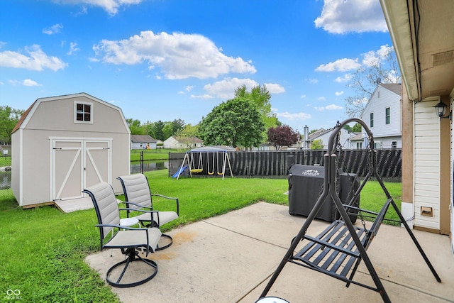 view of patio with a playground, a storage shed, and an outbuilding