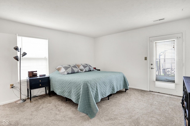bedroom featuring light colored carpet and baseboards