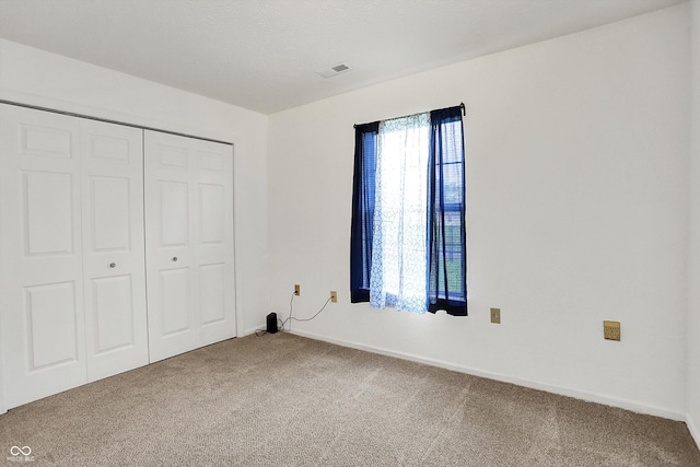 unfurnished bedroom featuring carpet, a closet, and baseboards