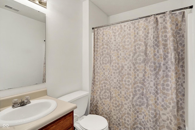 bathroom with toilet, vanity, and a shower with shower curtain