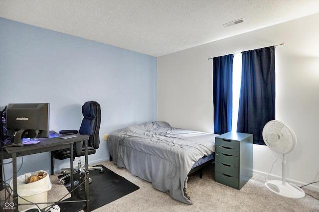 bedroom featuring light carpet, baseboards, a desk, and a textured ceiling