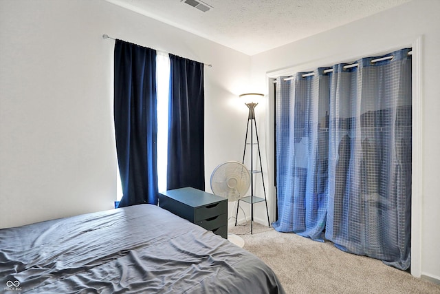 carpeted bedroom featuring a textured ceiling