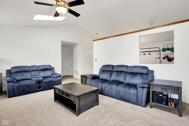 living room with a ceiling fan, carpet floors, lofted ceiling, and a skylight