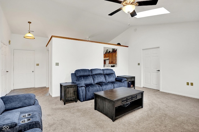 living area featuring a ceiling fan, vaulted ceiling, carpet, a skylight, and baseboards