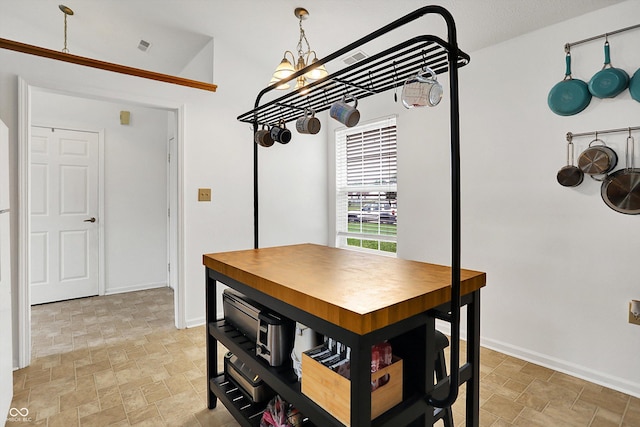 dining space featuring stone finish floors, a chandelier, and baseboards