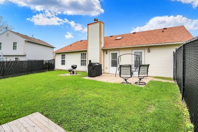 rear view of property featuring a chimney, a patio area, and roof with shingles