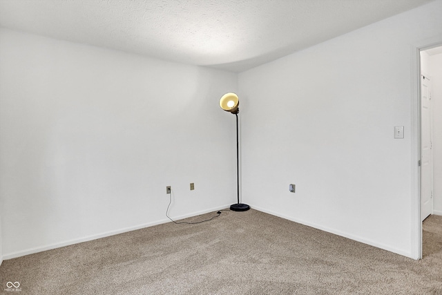 spare room featuring carpet flooring and baseboards