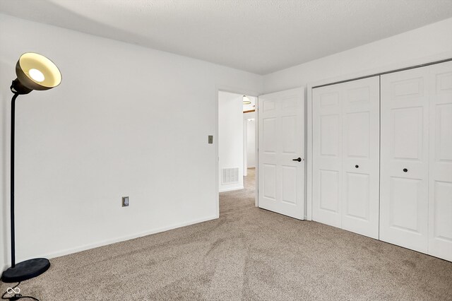unfurnished bedroom featuring carpet, a closet, and baseboards