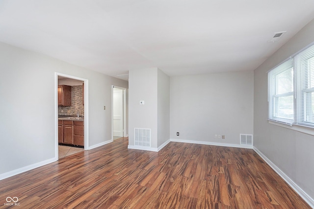 spare room featuring wood finished floors and baseboards