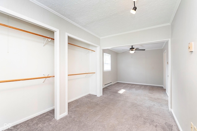 unfurnished bedroom with a baseboard radiator, carpet, crown molding, a textured ceiling, and two closets
