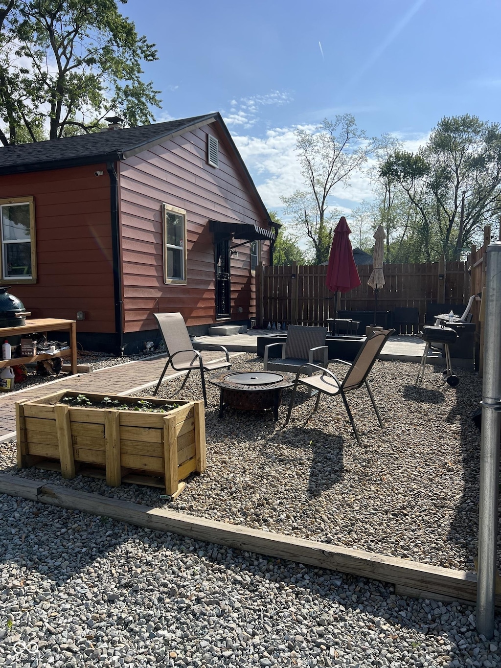 view of patio / terrace featuring an outdoor fire pit, fence, and a garden