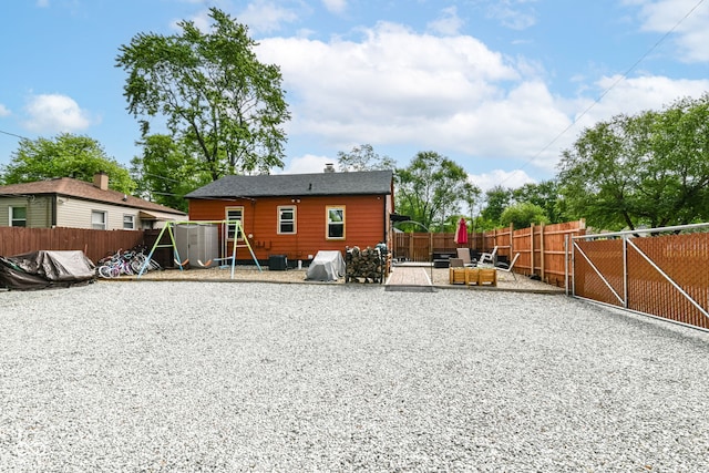 3302 N Gladstone Ave, Indianapolis, IN 46218 - rear view of house with a fenced backyard, a playground, and a patio area